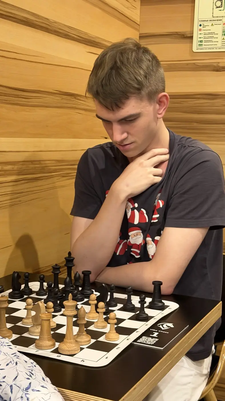 Игрок обдумывает позицию, держа руку у подбородка
