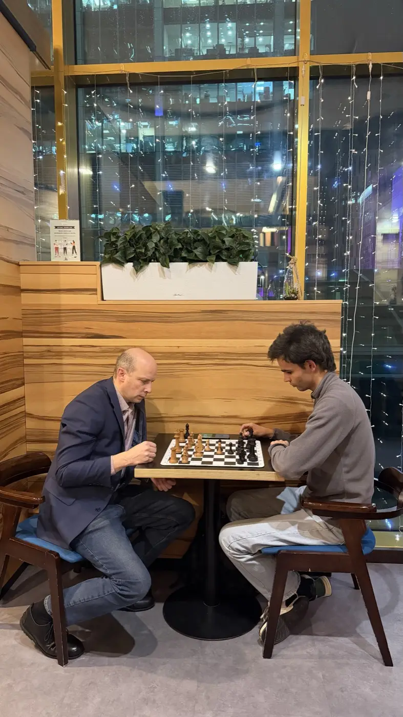 Шахматы в Москва-Сити: двое играют партию за столиком в Coffee Bean