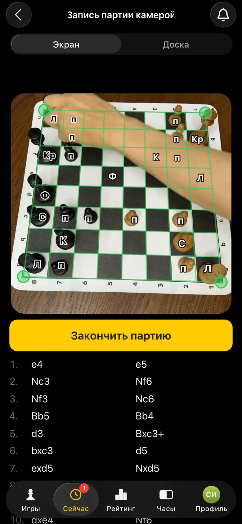 Вид с камеры: игрок делает ход, на доске размеченная сетка и подписи фигур